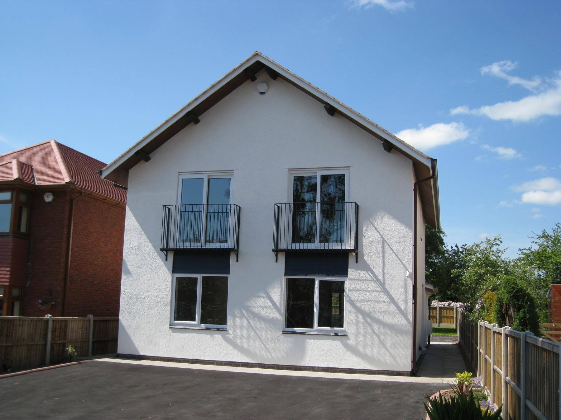 White rendered new build house with Juliet balconies